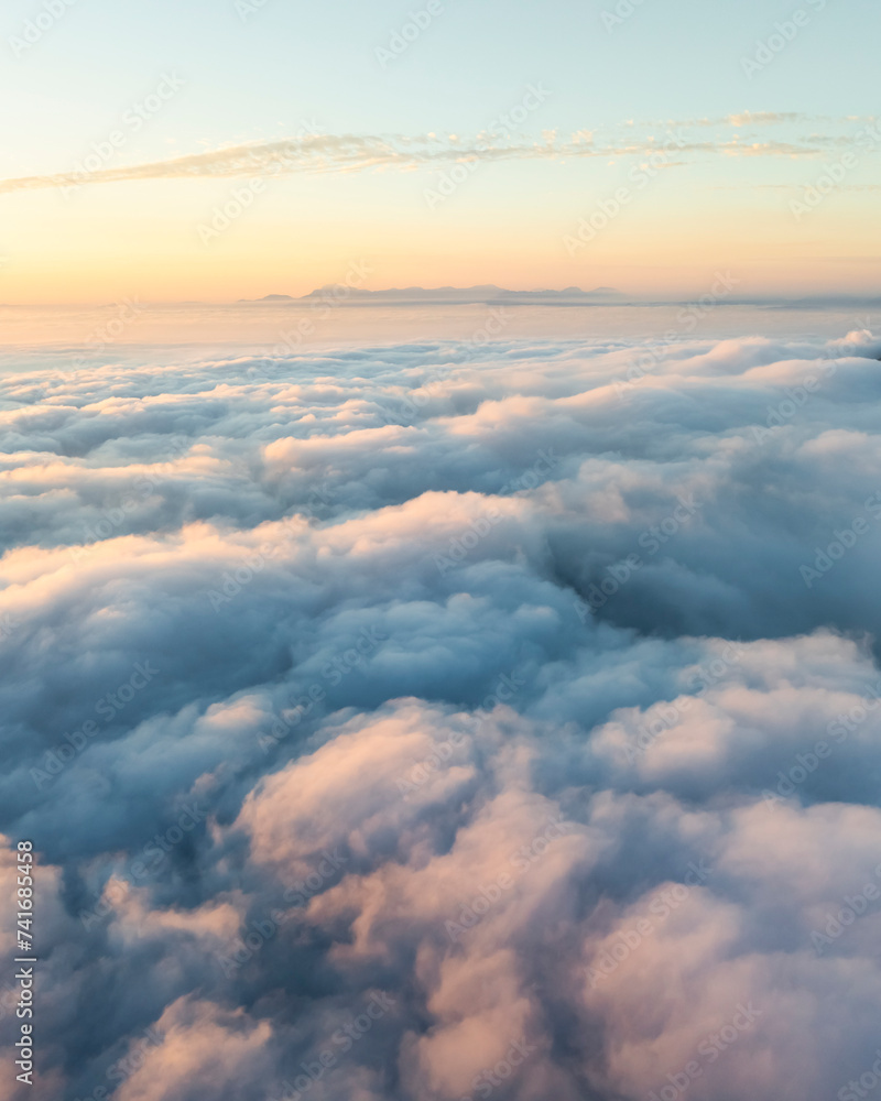 Aerial view of mountain range surrounded by low clouds at sunset and the Amalfi Coast in background as seen from the plane, Salerno, Campania, Italy. Aerial view of mountain range surrounded by low clouds at sunset and the Amalfi Coast in background as seen from the plane, Salerno, Campania, Italy.