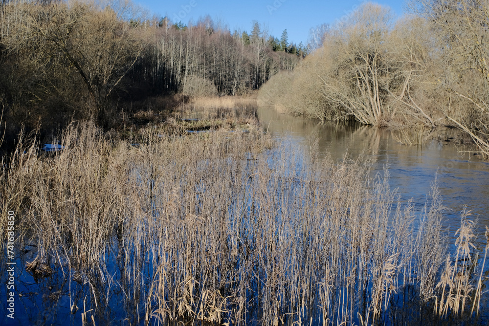 Overflown river Svitene in Latvia, Zemgale. Floods in sunny early spring day. Blue clear sky. Water on meadows and fields. Overflown river Svitene in Latvia, Zemgale. Floods in sunny early spring day. Blue clear sky. Water on meadows and fields.