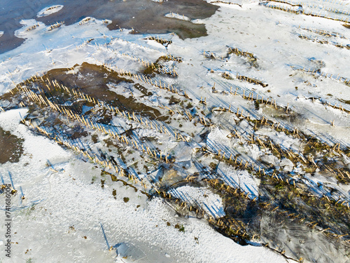 Aerial view of ice and snow on cropland with remains of corn plants on flooded floodplains, Maasheggen, Beugen, Noord-Brabant, Netherlands. photo