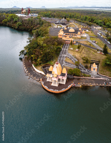 Aerial drone view of Ganga Talao, a Hindu pilgrimage site with temples and crater lake and the gigantic statues of Lord Shiva and Durga Maa Bhavani in the background, Grand Bassin, Savanne, Mauritius. photo