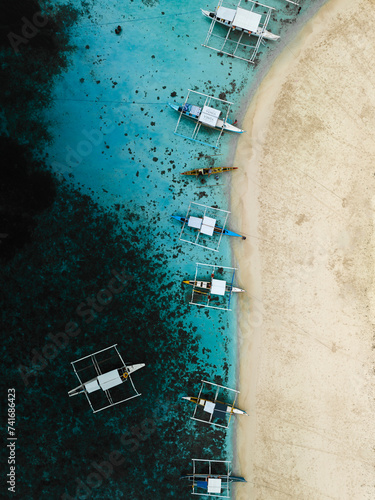 Aerial drone view of long tail touristic boats docked along the naked island Siargao, Surigao del Norte, Philippines. photo