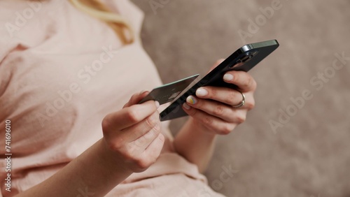 Hands of young women shopping online using a credit card. woman uses smartphone and makes online transactions at home. Online shopping concept with technology and new normal lifestyle
