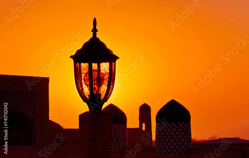 Silhouette of a lamp and minarets at sunset, Khiva, Khorazm, Uzbekistan photo