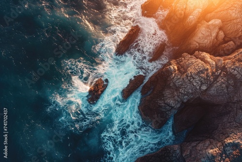 Aerial View of the Ocean and Rocky Shoreline at Sunset, Illuminating aerial portrayal of a sunlit sea contrasted against dark rocks, AI Generated