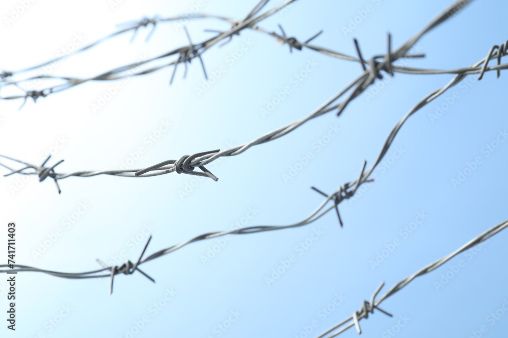 Metal barbed wire on light blue background Metal barbed wire on light blue background