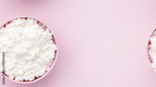 Cottage cheese in a bowl on pink background with copy space