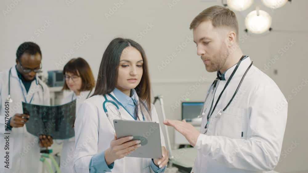 Group of doctors examining medical images on tablet Group of doctors examining medical images on tablet