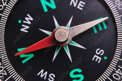 Dial compass in closeup, arrow indicates direction west.