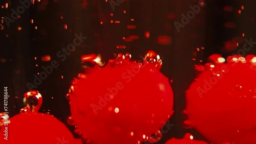 bolas rojas abstractas con burbujas moviéndose en un líquido rojizo photo