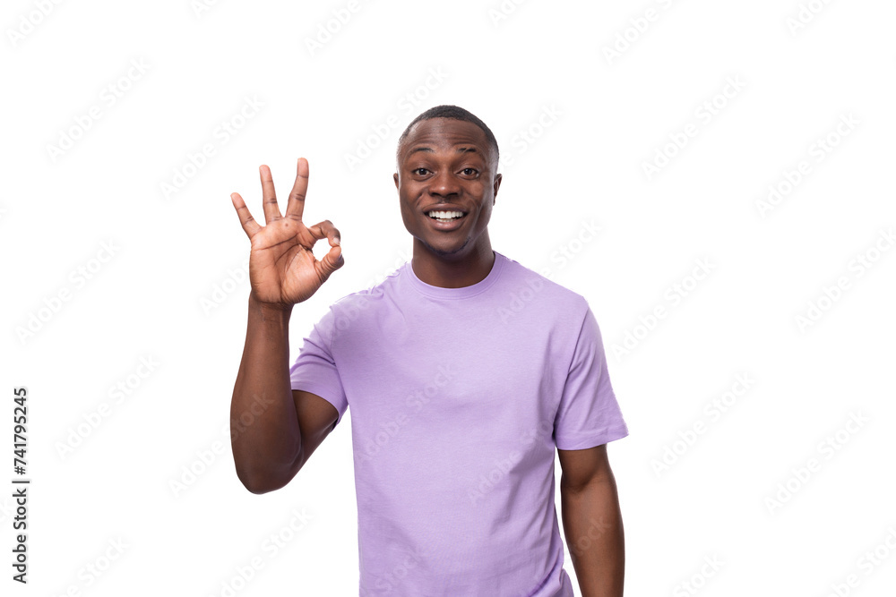 close-up portrait of a young laughing african man in a lilac t-shirt making a grimace close-up portrait of a young laughing african man in a lilac t-shirt making a grimace