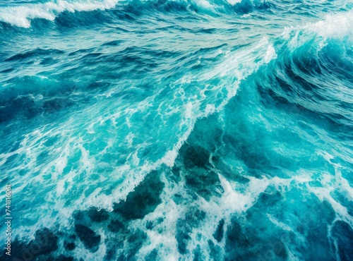 Beautiful photo of blue water flowing in waves with white foam in a ocean. Wallpaper background.