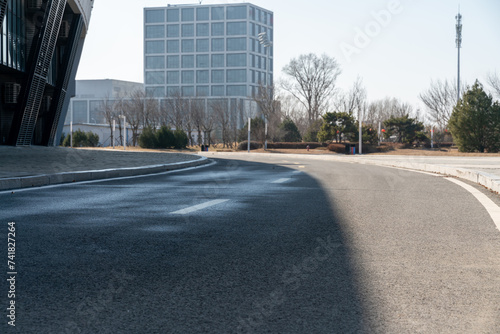 empty asphalt road in downtown of modern city during daytime.