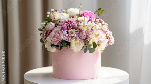 Chic Floral Gift: Pink Round Box with Beautiful Bouquet on a White Table. Stylish and Elegant Decoration for Celebrations like Weddings, Birthdays, and More © pvl0707