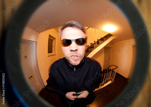 Tableau sur toile view through door viewer into a staircase, peephole, spyhole, with a man in fron