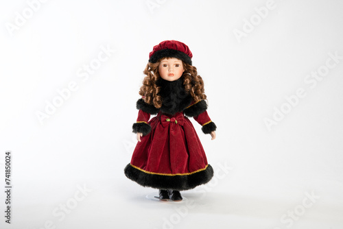 Beautiful doll in a red dress and hat. On a white background