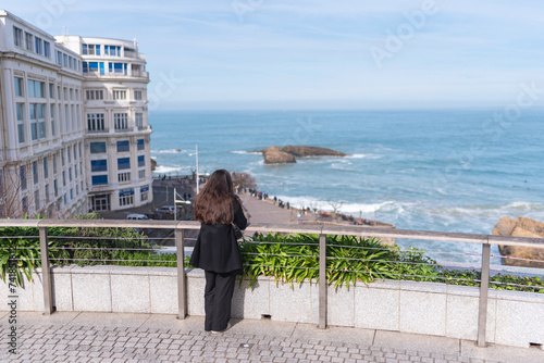 Tourist with long hair contemplates the sea in Biarritz. French Basque Country photo