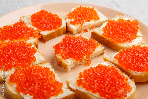 Sandwiches with red caviar on a table on a white tablecloth close-up