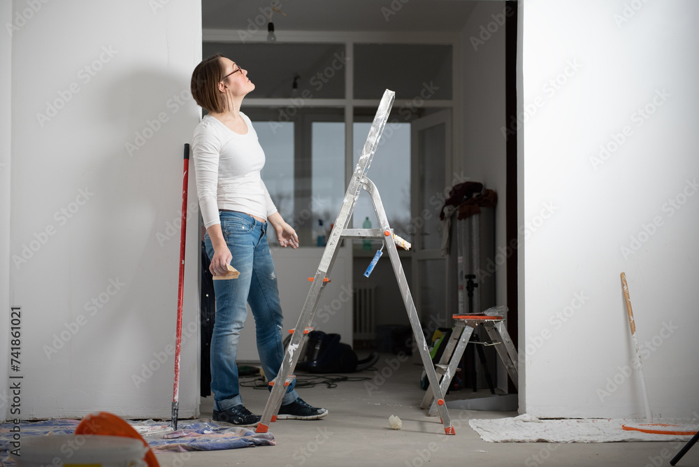 Young happy woman paints her apartment