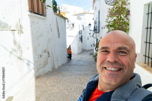Happy tourist takes a selfie sign thums up, in Altea, Alicante (Spain). photo