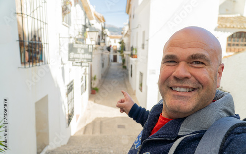 Happy tourist takes a selfie sign thums up, in Altea, Alicante (Spain). photo