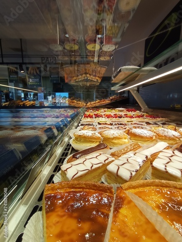 bright french pastries in a baker window, with millefeuille, flan and fruits tarts