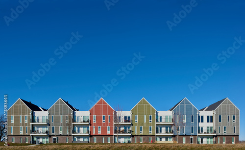 Apartments and condominiums in an area of urban expansion. Colorful buildings and blue sky.