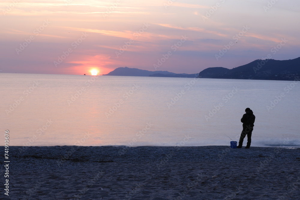 Fototapeta premium silhouette of a person walking on the beach
