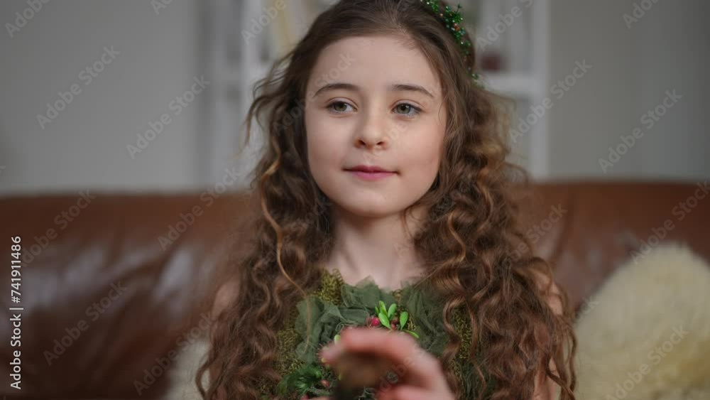 Close-up. A beautiful preteen girl with long hair looks at the camera ...