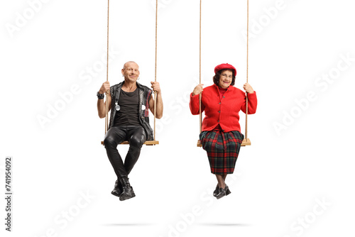 Punk and an elderly man sitting on swings and looking at camera photo