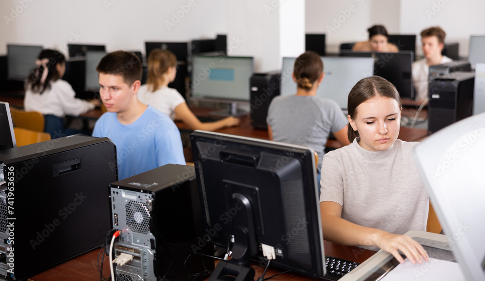 Fototapeta premium Focused girl using scanner in computer room in school