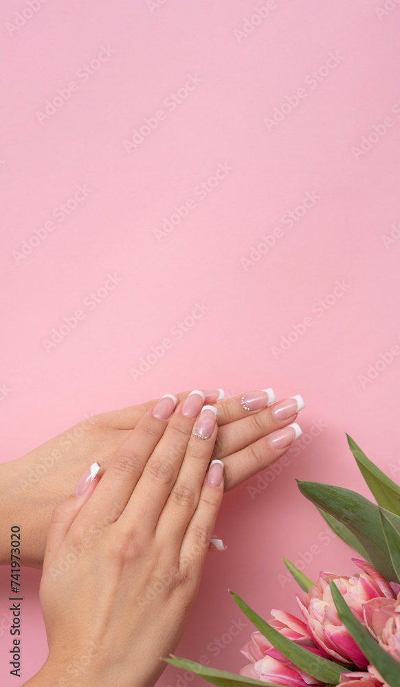 Perfect done manicure on a pastel pink background.