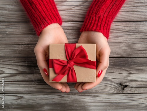 manos de una joven sosteniendo una caja de regalos con papel de regalo y un lazo, san ValentÃ­n, vista superior, colores en tonos rojos --ar 4:3 --v 6 Job ID: 51e2c116-e846-4973-a94f-aba4fb524237 photo