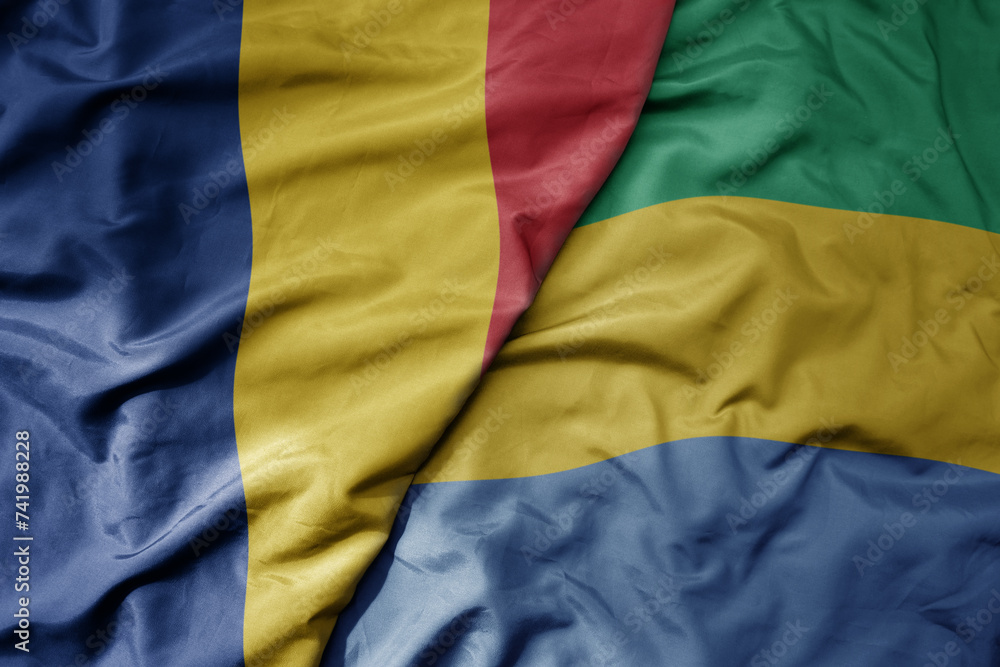 big waving national colorful flag of gabon and national flag of romania . big waving national colorful flag of gabon and national flag of romania .