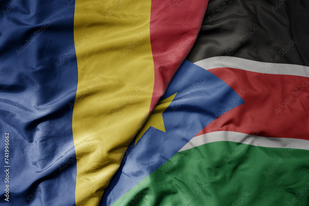 big waving national colorful flag of south sudan and national flag of romania .