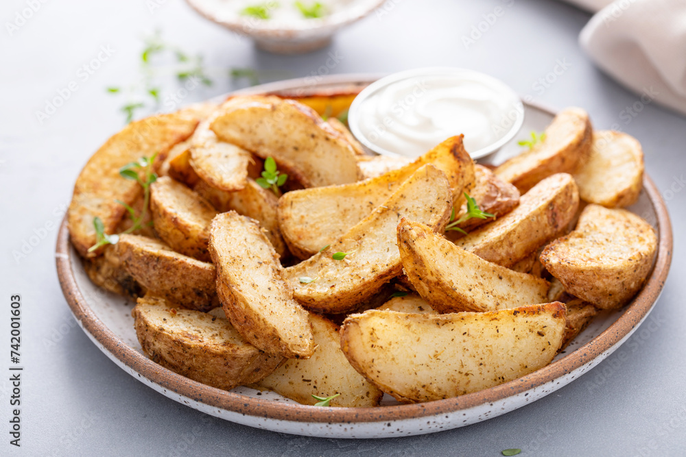 Roasted potatoes with parmesan and herbs served with creamy sauce for dipping Roasted potatoes with parmesan and herbs served with creamy sauce for dipping