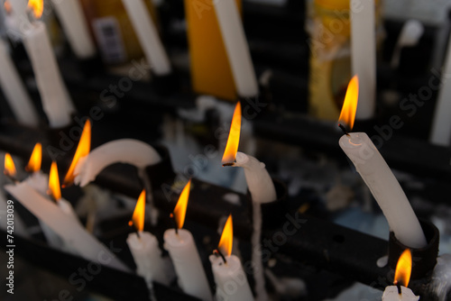 Several lit candles burning during the day. Concept of religiosity. photo