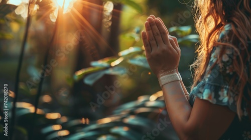 Woman hands praying for blessing from god on sunset background photo