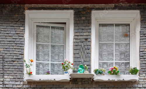 Hausfassade mit zwei Fenstern, Deko aus Kunstblumen, Morlaix