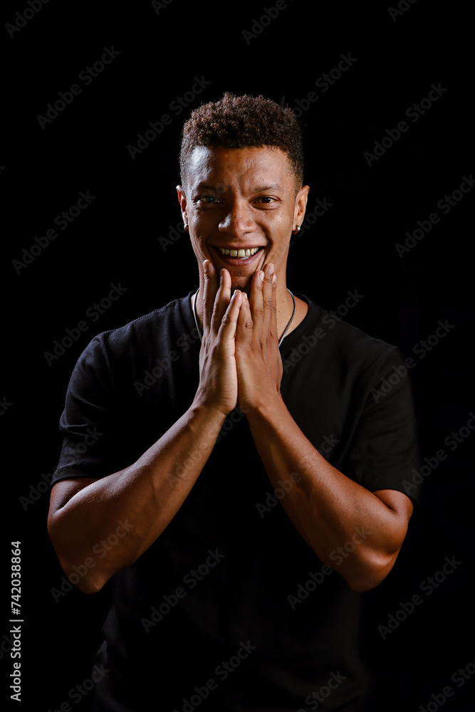 Portrait of young African man smiling with black background