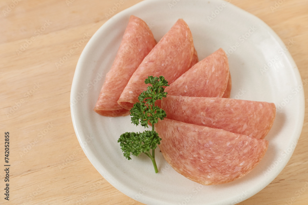 お皿に盛りつけられたスライスしたサラミ お皿に盛りつけられたスライスしたサラミ