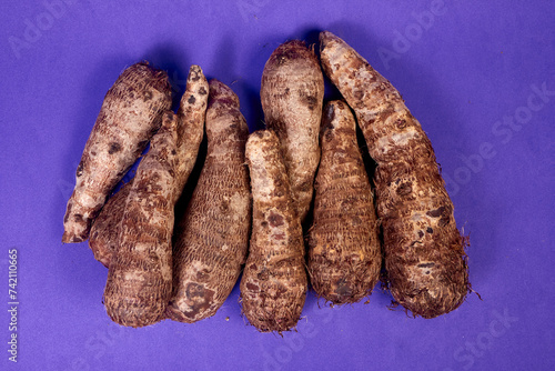 closeup of taro root vegetable, eddo malanga, purple background photo