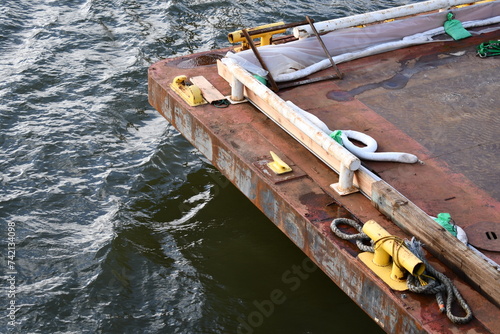 Corroded barge in choppy water. Large mooring cleats. photo