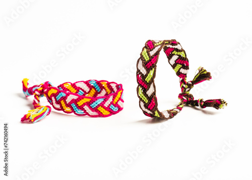 Multicolored woven DIY friendship bracelets handmade of embroidery bright thread with knots isolated on white background