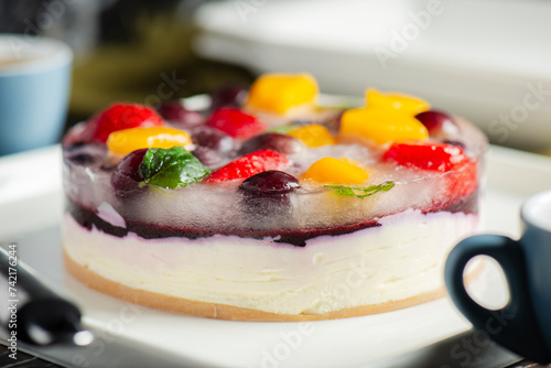 Delicious and light no-bake cheesecake with summer fruits including strawberry, mango, and grapes.
