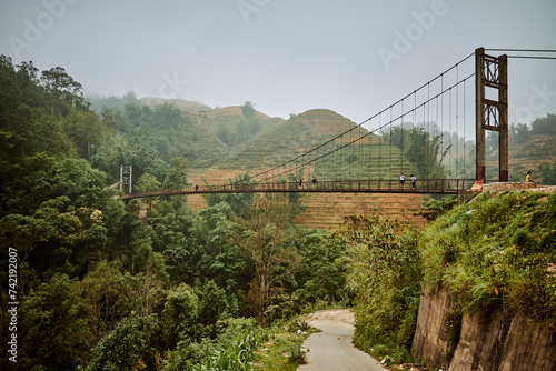 bridge over river and misty jungle mountains in sapa, vietnam
