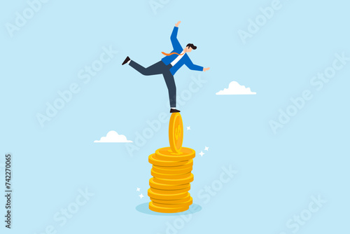 Businessman balancing on unstable stacks of coins