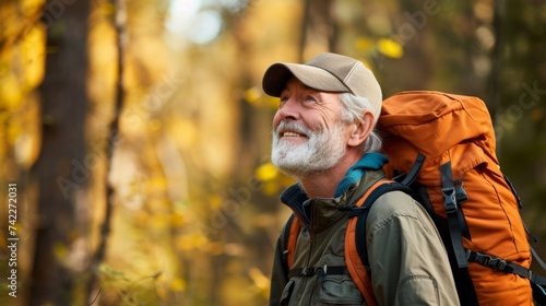 A senior man pausing to take a deep breath and fill his lungs with the crisp clean air as he explores a wooded trail.