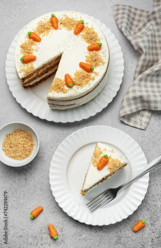 Homemade carrot cake made with walnuts, iced with cream cheese. Sweet dessert.