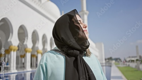 A smiling woman wearing a hijab at the sheikh zayed grand mosque in abu dhabi, uae. photo