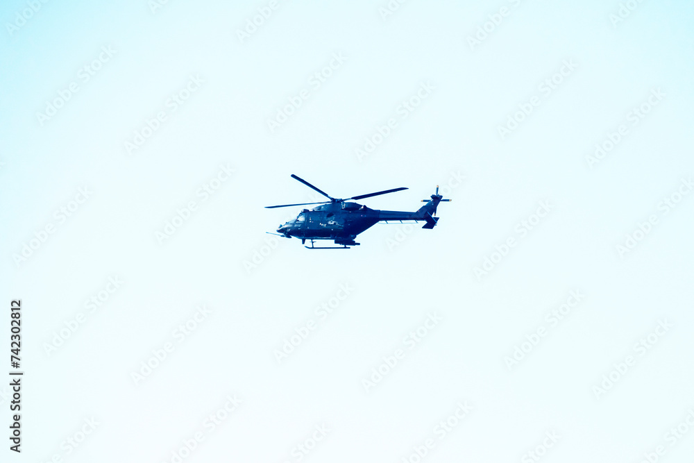helicopter is flying on isolated blue sky. helicopter is flying on isolated blue sky.